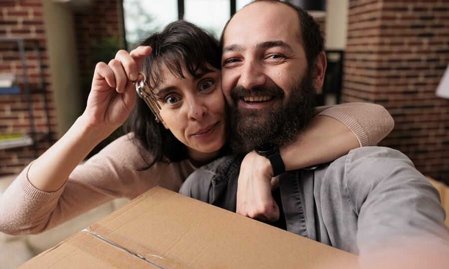 Property homeowners holding keys of first house bought together