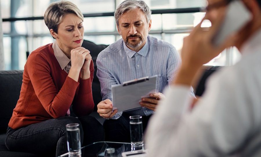 Suspicious couple going through insurance agreement while being